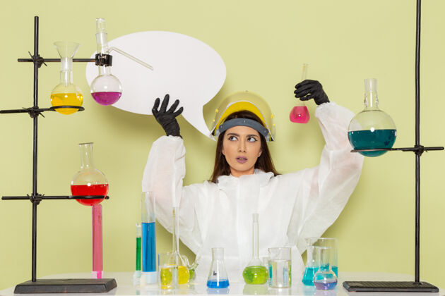 保持正面图身着特殊防护服的女化学家手持绿色表面的白色大标牌化学工人大