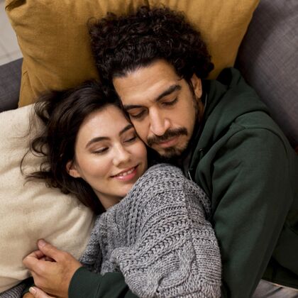 关怀男人睡觉时抱着妻子感情舒适夫妇
