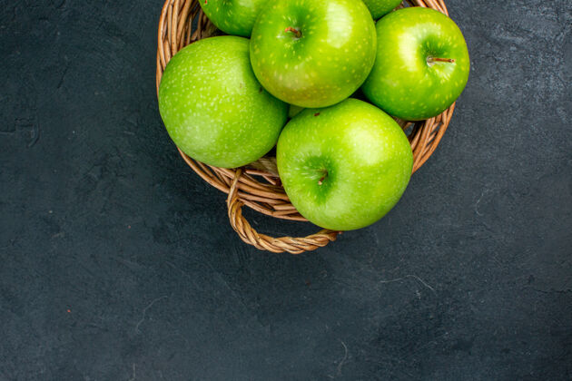水果顶视图新鲜苹果柳条篮子在黑暗的表面维生素新鲜苹果柳条