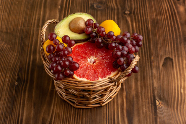 可食用水果正面是棕色木质书桌上篮子里不同的水果水果内部桌子