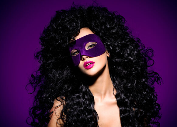 发型一个美丽的女人的肖像 黑色的头发和紫色的戏剧面具在脸上紫色的指甲漂亮卷发魅力