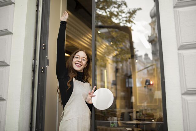 工人笑脸女人站在餐厅门口工作商店短裤商业