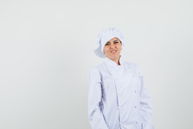 举行女厨师穿着白色制服看着镜头 神情欢快烹饪新鲜美食