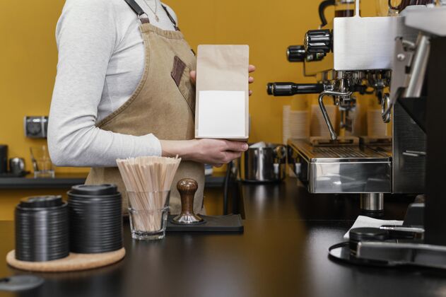 工作女咖啡师磨咖啡豆的侧视图服务员专业女