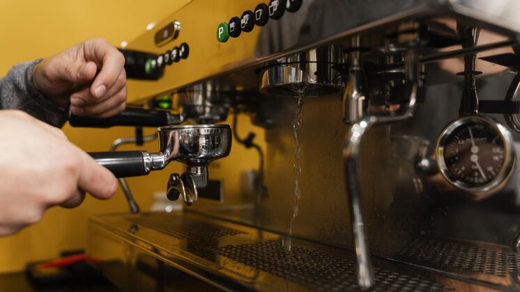 服务员男咖啡师使用专业咖啡机的侧视图雇员职业咖啡馆