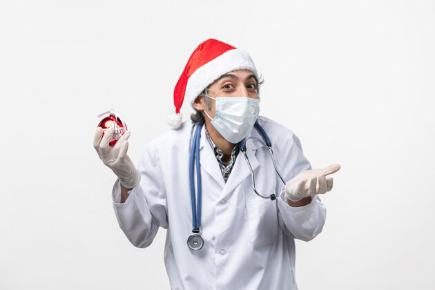 外套男医生手捧新年树玩具地板健康冠状病毒制服听诊器圣诞节