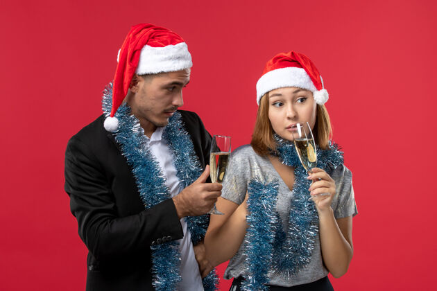 成人前视图年轻夫妇庆祝新年红桌爱党圣诞节男人风景微笑