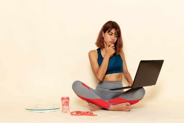 衬衫年轻女性穿着蓝色衬衫 在浅白的墙上使用笔记本电脑 身体健康笔记本电脑快乐锻炼