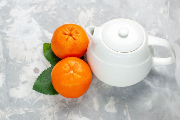 柑橘正面是新鲜的橘子 白色表面有水壶柑橘多汁异国情调