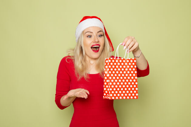 色彩前景靓女抱着礼物在绿墙小包装上节日圣诞色新年感慨肖像微笑圣诞