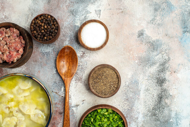 绿色顶视图杜什巴拉碗不同香料绿色肉木勺裸体表面自由空间勺子杜什巴拉胡椒