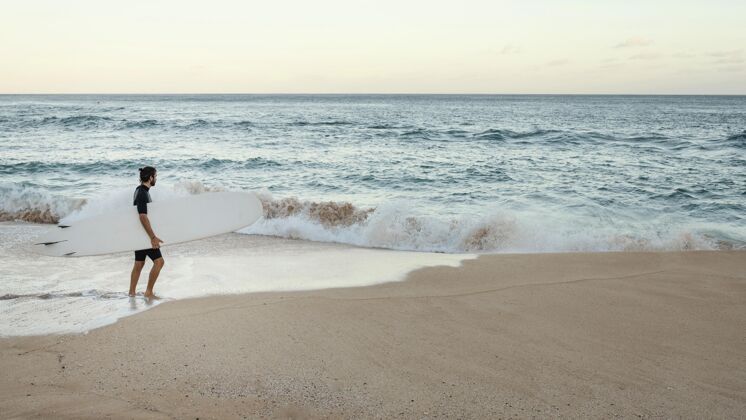 夏威夷一个拿着冲浪板的人海洋运动员海滩