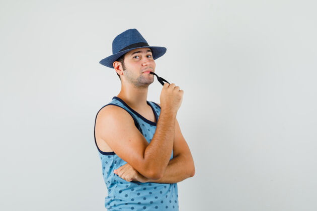 胡须一个戴着眼镜 戴着蓝色单打帽子 表情积极的年轻人衬衫积极休闲