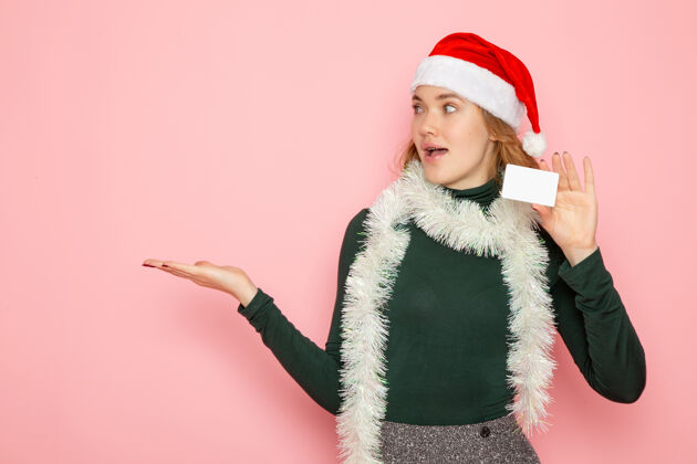 服装正面图年轻女性手握银行卡粉色墙面色彩情感模型节日圣诞新年帽子围巾圣诞