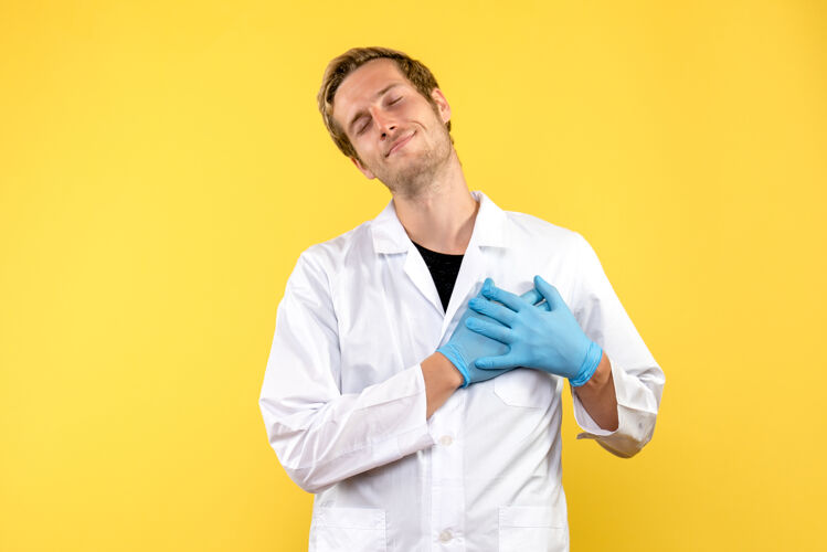 男性医生正面图黄色背景上微笑的男医生医学人类大流行病毒流行病实验室外套微笑