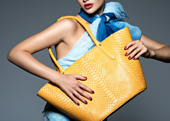 购物穿着蓝色围巾配黄色手提包的时尚美女时尚模特奢侈品女人指甲