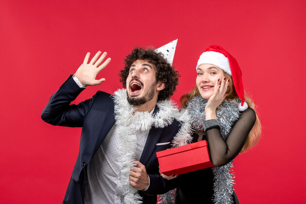 表演者红墙彩绘圣诞爱情派对上 一对年轻情侣带着新年礼物出现在眼前明星成人年轻夫妇