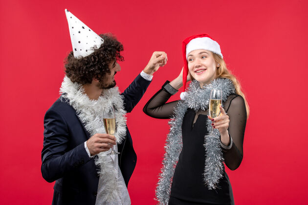 服装前视图年轻夫妇刚刚庆祝新年在红墙党爱圣诞节表演服装庆祝