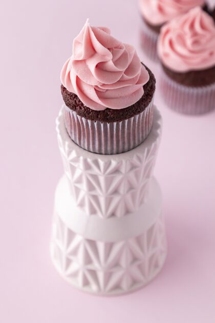 奶油美味的粉红色纸杯蛋糕高角度烘焙安排美味