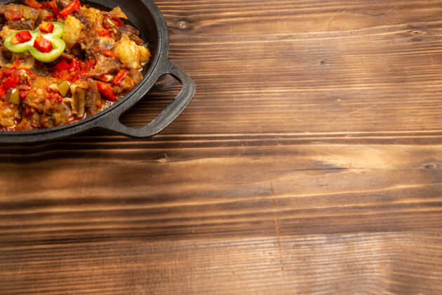 菜前视图煮熟的蔬菜餐在棕色表面锅内胡椒炒的餐厅