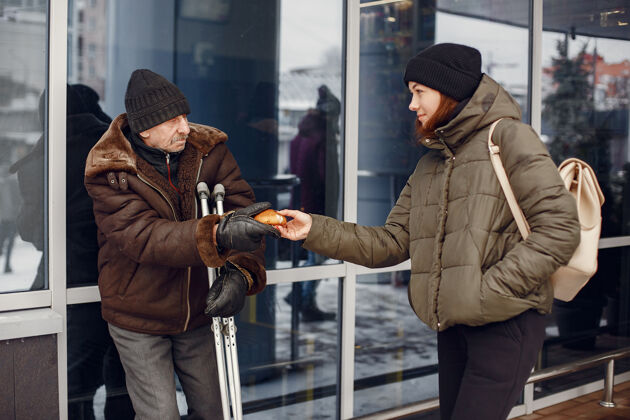 男人在一个冬天的城市里无家可归有人要食物街道纸板食物