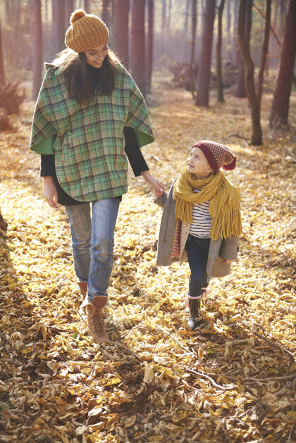 树叶和妈妈在森林里散步小女孩父母女儿