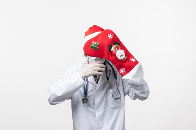 男医生正面图白色墙上戴着大红袜子的男医生病毒冠状病毒-圣诞节冠状病毒袜子病毒