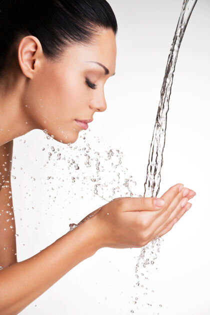 湿一位美女用水洗脸的特写照片新鲜皮肤水疗