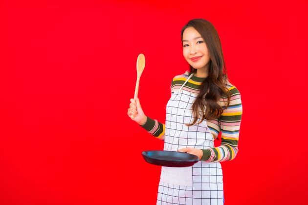板画像美丽的亚洲年轻女子拿着锅准备在红墙上做饭西兰花厨房炉子