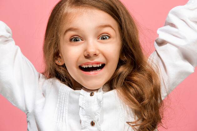 女性快乐的少女站在时尚的粉色工作室里 微笑着童年可爱成人