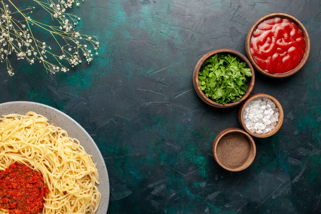 钱顶视图煮熟的意大利面食与肉和不同的调味品在深蓝色的表面午餐不同的顶部