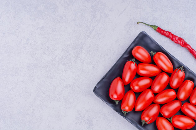 健康樱桃番茄和红辣椒放在陶瓷盘子里辣椒食物品质