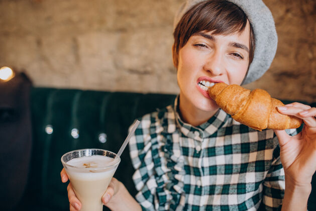看在咖啡馆喝拿铁吃羊角面包的法国女人杯子美味自助餐厅