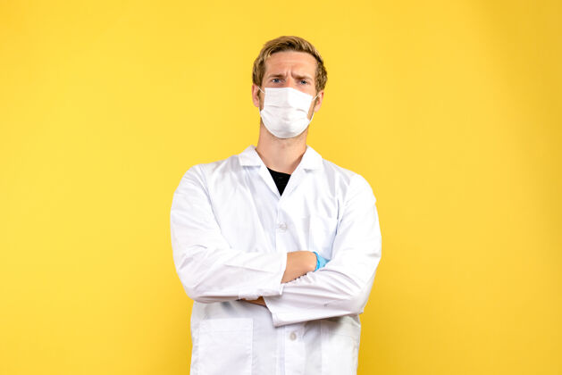 人正面图黄色背景上戴面罩的男医生-医疗卫生大流行流行病Covid男性