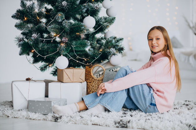 毛衣坐在圣诞树旁的小女孩雪人爱