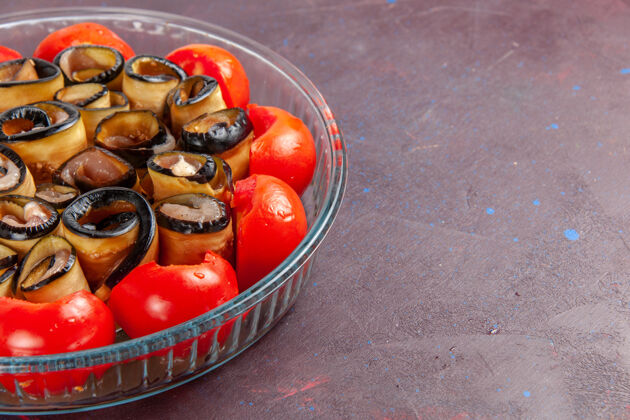 烹饪前面近距离观看蔬菜餐切片和滚动番茄茄子在黑暗的表面饮食封闭健康