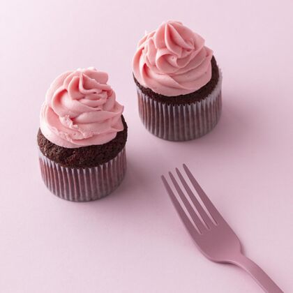 甜点粉红色糖衣和叉子做成的高角度纸杯蛋糕奶油方形美味