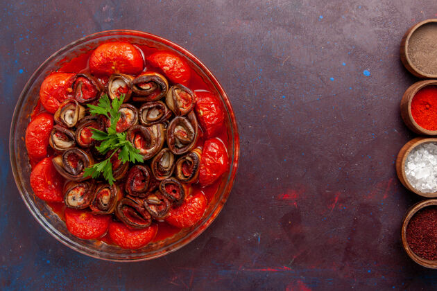 餐俯瞰烹饪蔬菜餐美味的西红柿和茄子与调味品在黑暗的表面调味料菜玻璃