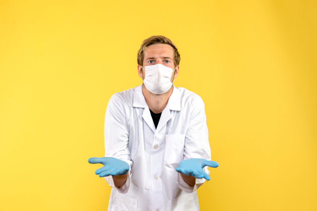 大流行前视图男性医生困惑于黄色背景健康病毒-医学大流行衣服困惑微笑