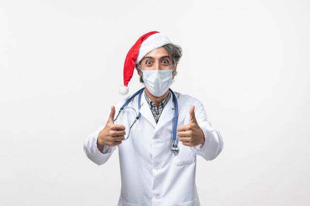 圣诞节正面图男医生带着无菌口罩上白墙新年病毒大流行冠状病毒药品大流行