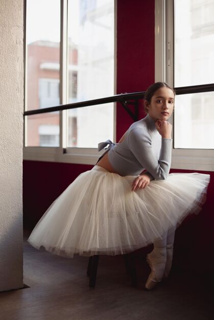 芭蕾舞侧视图芭蕾舞演员在图图裙子摆在旁边的窗口表演芭蕾舞蹈
