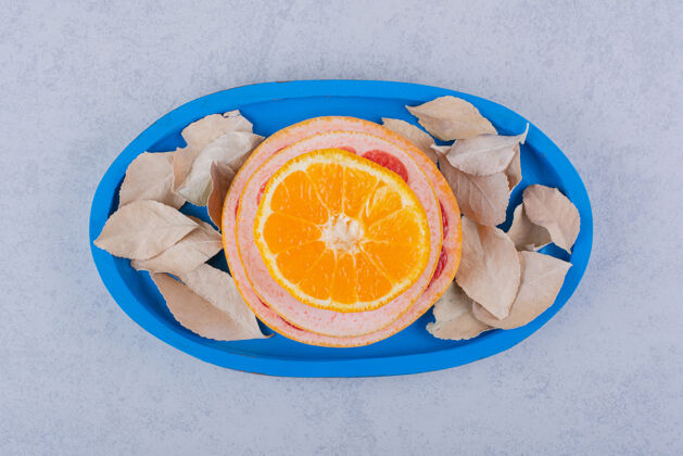 柑橘新鲜的葡萄柚 柠檬和橙色的戒指放在蓝色的盘子里水果生的圆形