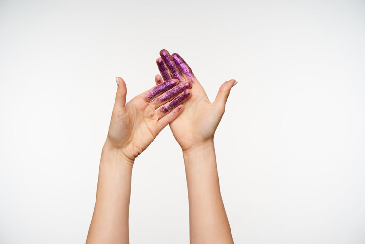 情绪年轻的皮肤白皙漂亮的手的正面图显示手掌紫罗兰色闪烁 同时摆出孤立站在白色人类的手和手势的概念绘画女人站立