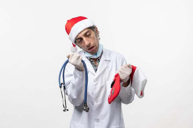 病毒正面图男医生拿着节日袜白墙病毒covid节日健康医院圣诞节听诊器