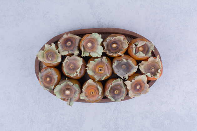 四季在灰色表面的木制盘子里放上李子枣食物新鲜甜味