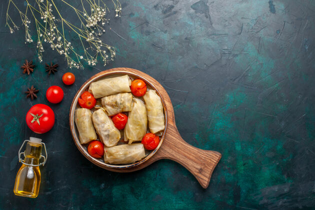 菜俯瞰图美味的肉食卷心菜和西红柿称为dolma橄榄油在深蓝色的桌子上油晚餐多尔玛
