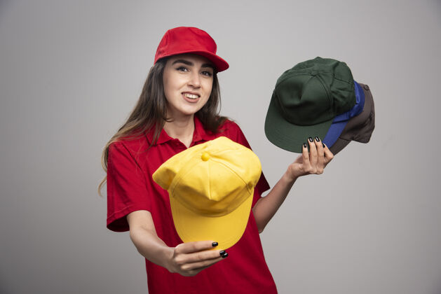 雇员一个戴着彩色帽子的女送货员送了一个承运人女女