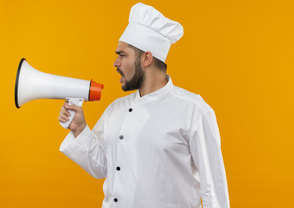 橙色穿着厨师制服的年轻男厨师站在讲话者一边说话 一边看着橙色空间里与世隔绝的一面未发布厨师演讲者