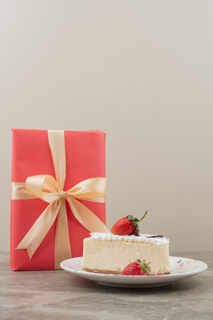 奶油草莓芝士蛋糕和大理石桌上的礼物盘子礼物圣诞节