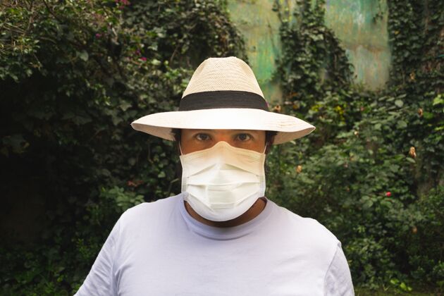 面具戴着白色面罩戴着帽子的男人 以防灰尘和冠状病毒病毒防护衬衫
